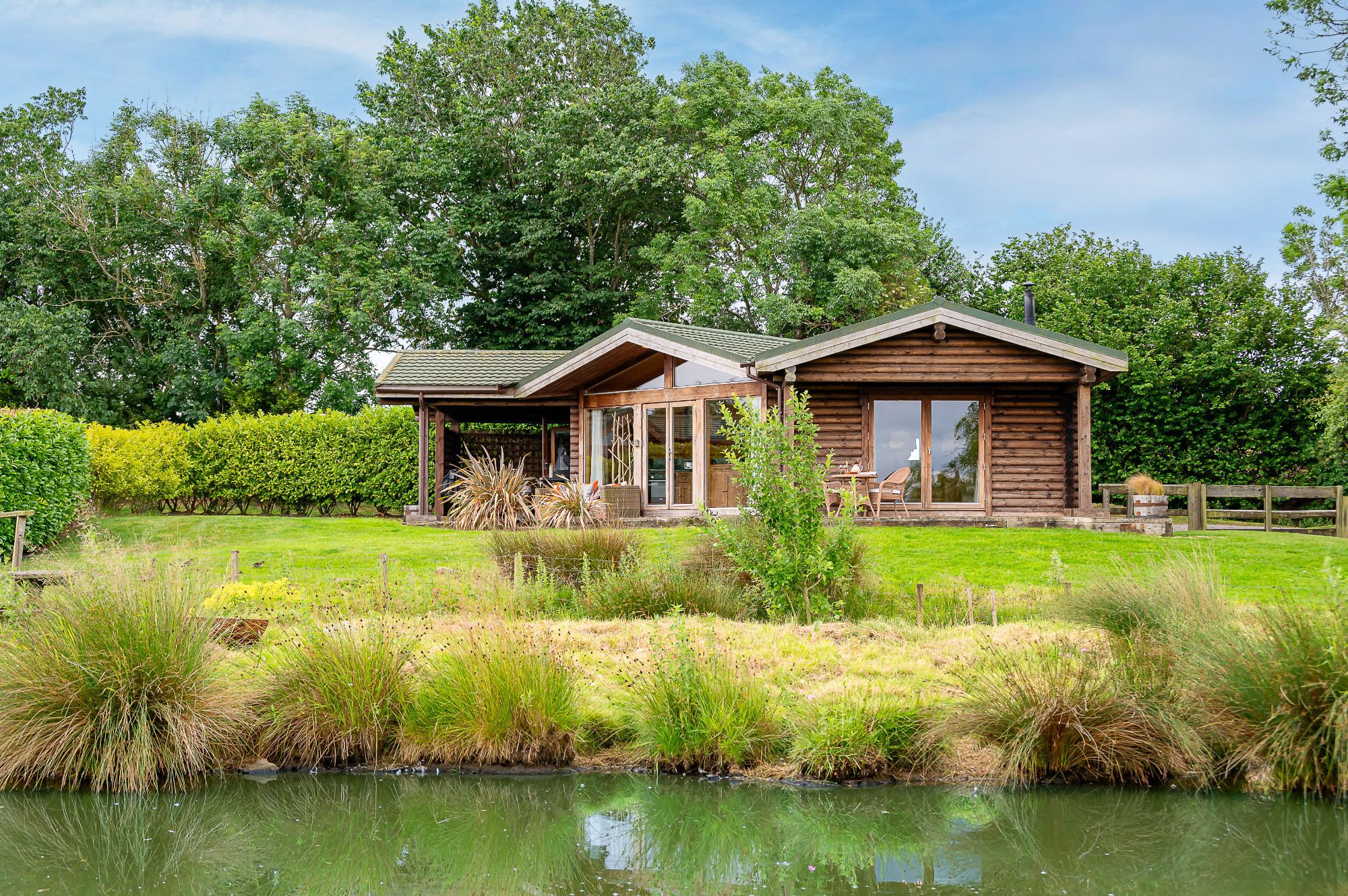 Exterior of Lillie lodge with large lawn and countryside setting at Sun Hill Lodges.
