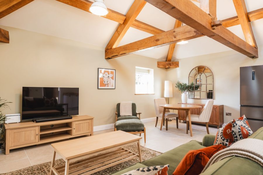 Open-plan living area in Whitwell Nook, North Yorkshire with exposed beams, and dining space.