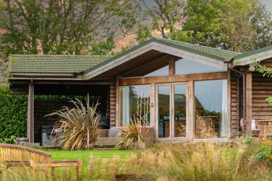 Exterior of Lillie lodge with large lawn and countryside setting at Sun Hill Lodges.