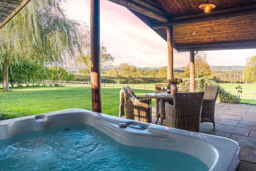 Private hot tub with countryside views at Pivotal luxury lodge.