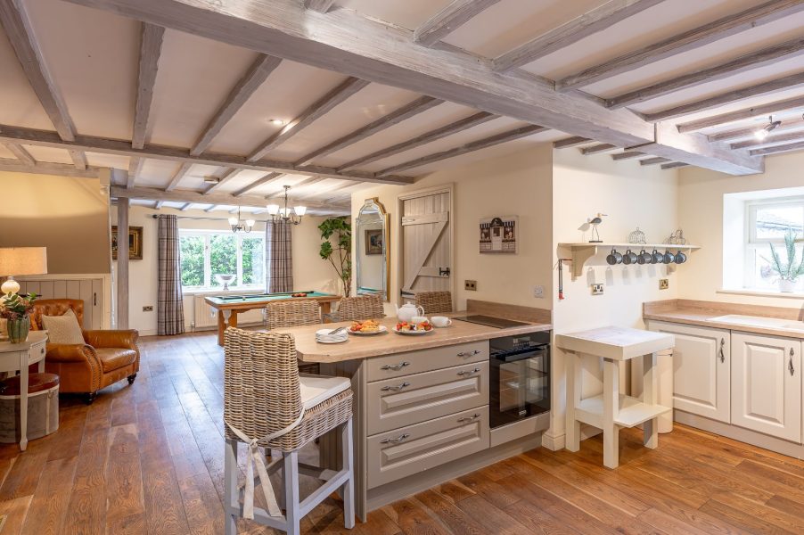 Open-plan kitchen and living area at Sun Hill Cottage with wooden beams