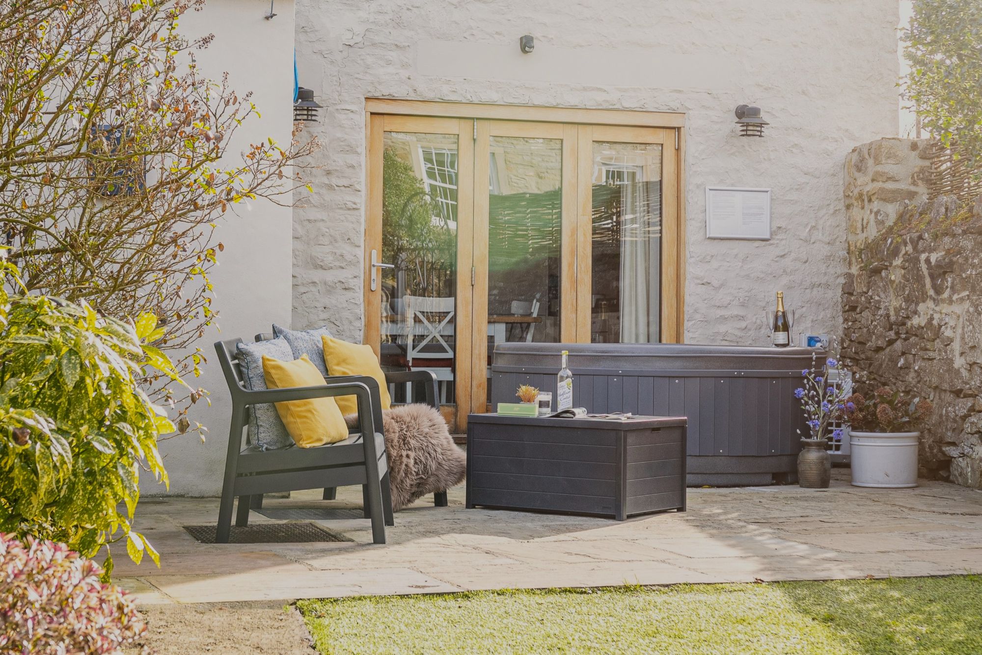 Woodcroft Cottage garden with hot tub, outdoor seating and enclosed private space for relaxing holiday breaks.