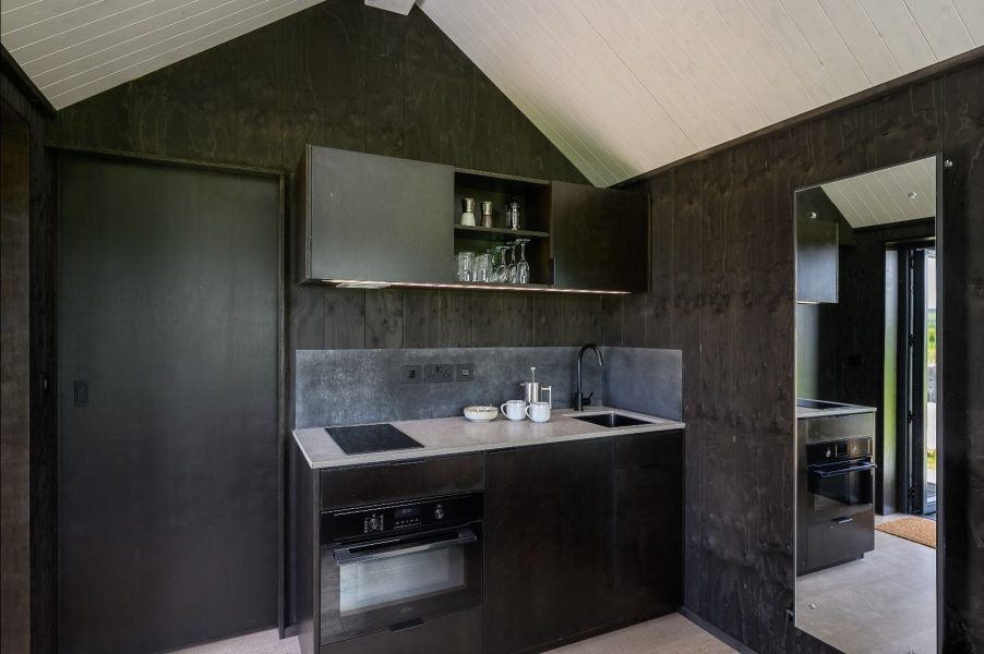 Contemporary kitchenette with black cabinetry inside a Greenbank Lodges retreat