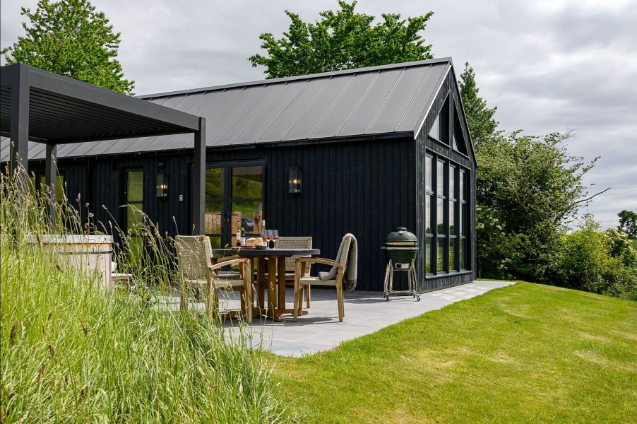Exterior of Ake Lodge with private patio, hot tub, barbecue and scenic North Yorkshire countryside surroundings.