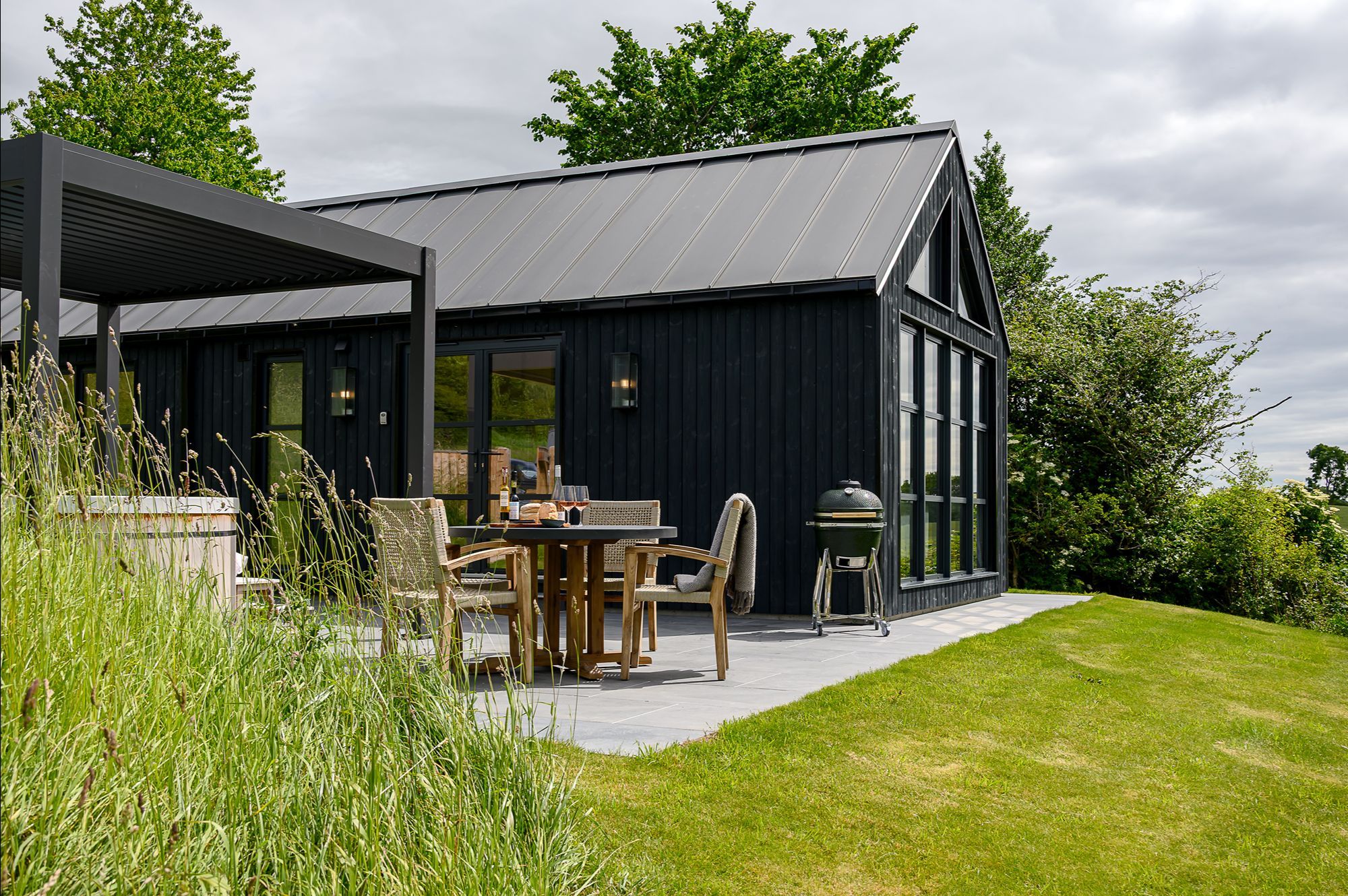 Exterior of Ake Lodge with private patio, hot tub, barbecue and scenic North Yorkshire countryside surroundings.
