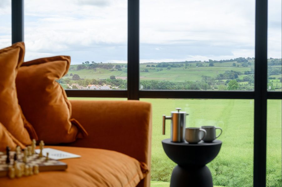 Comfortable lounge seating in Olof lodge with countryside views through large picture windows in North Yorkshire.