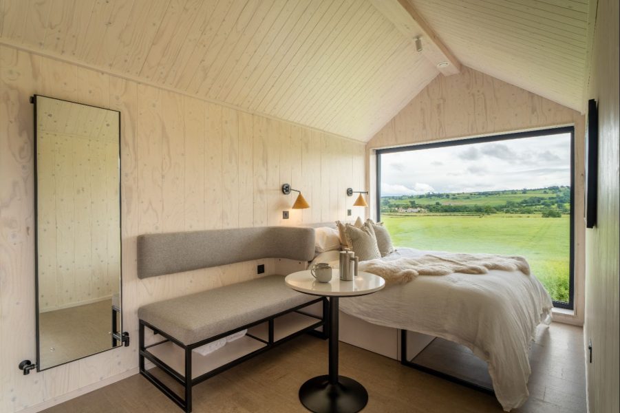 Contemporary lodge interior featuring a king-size bed, seating area and views across the Yorkshire countryside.