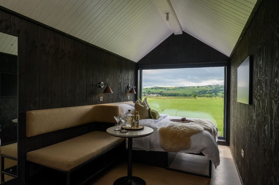 Dark Scandinavian lodge bedroom with panoramic countryside views across North Yorkshire