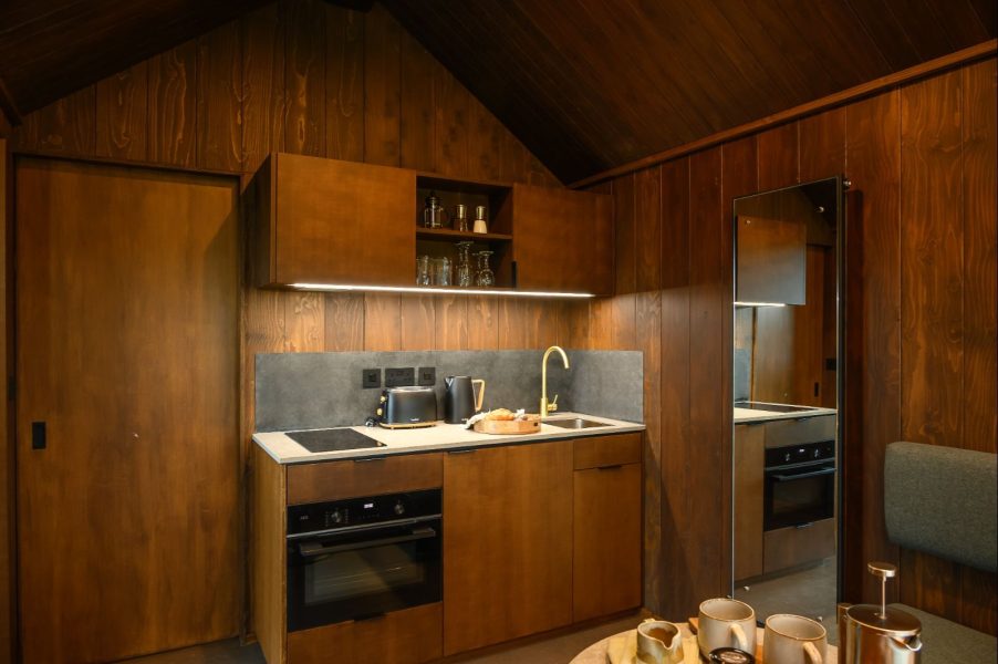 Modern kitchenette inside Elvar lodge featuring bespoke wood interiors and premium self-catering facilities.