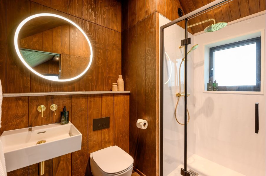 Contemporary bathroom in Elvar lodge with rainfall shower, designer lighting and luxury finishes.