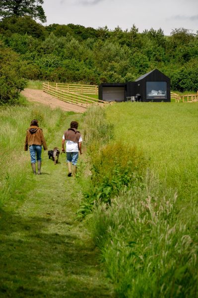 Guests walking towards Von at Greenbank Lodges with their dog.