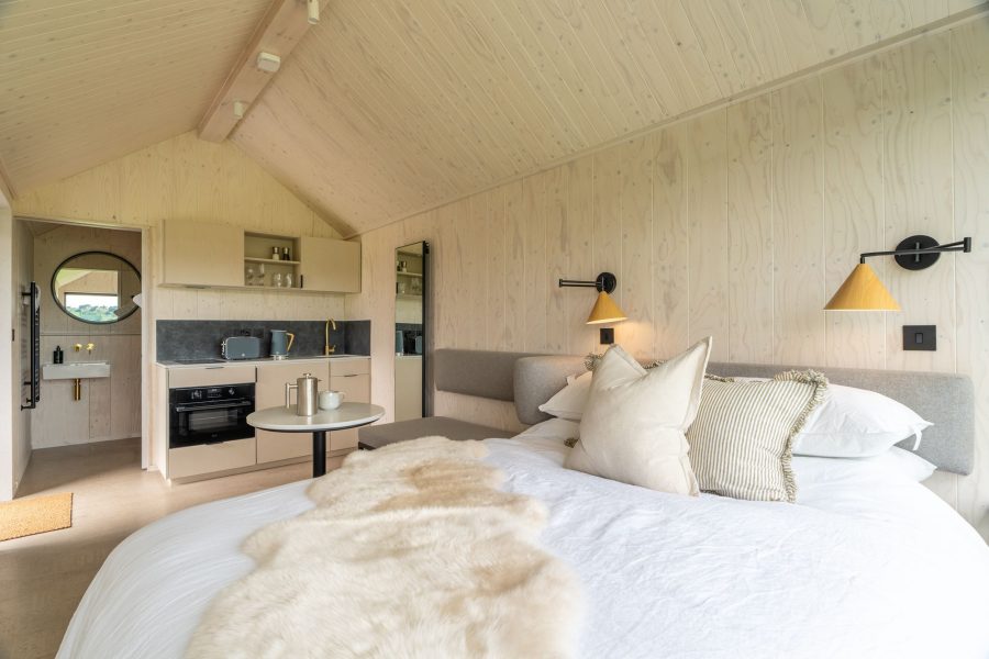 Open-plan luxury lodge with kitchenette, dining area, king-size bed and countryside views.