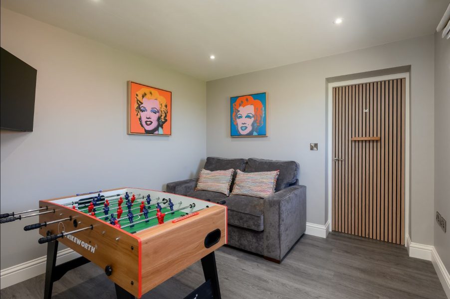 Field Cottage games room with foosball table, sofa seating, and modern artwork.