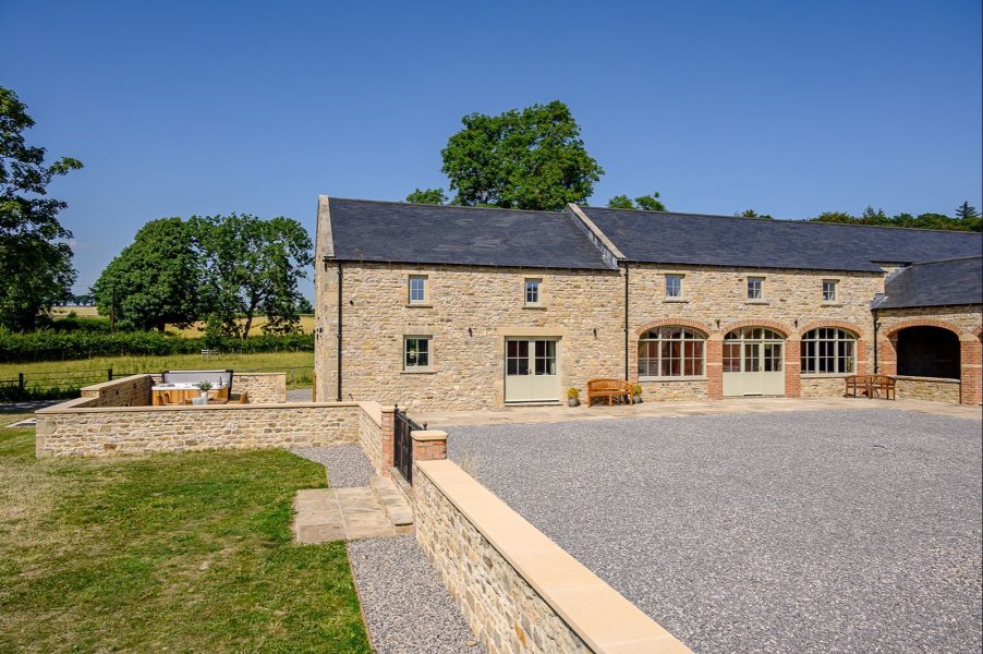 Exterior view of Hollins Barn, a beautifully restored stone holiday home with private courtyard, hot tub and ample parking in the Peak District.