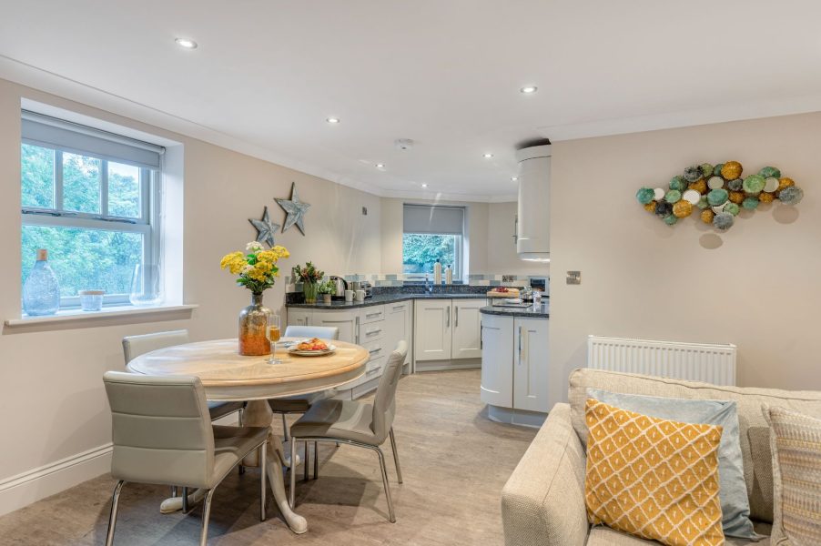 Bright open-plan kitchen diner with round table at Darcy Mews accommodation