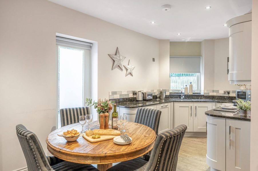 Open-plan kitchen diner with wooden table and modern fittings at No.5 Darcy Mews