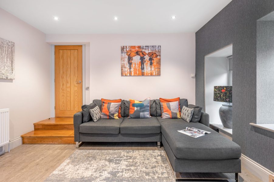 Stylish living room with corner sofa and modern artwork at No.5 Darcy Mews