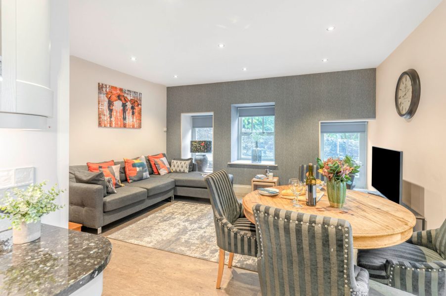 Spacious open-plan living and dining area with feature wall at Darcy Mews accommodation