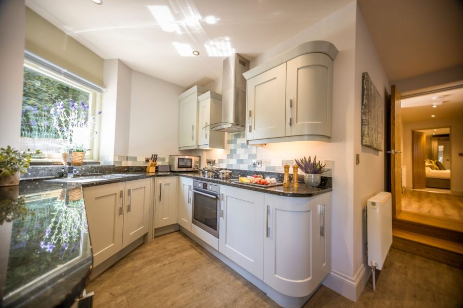 Contemporary kitchen with granite worktops and integrated appliances at Darcy Mews holiday home