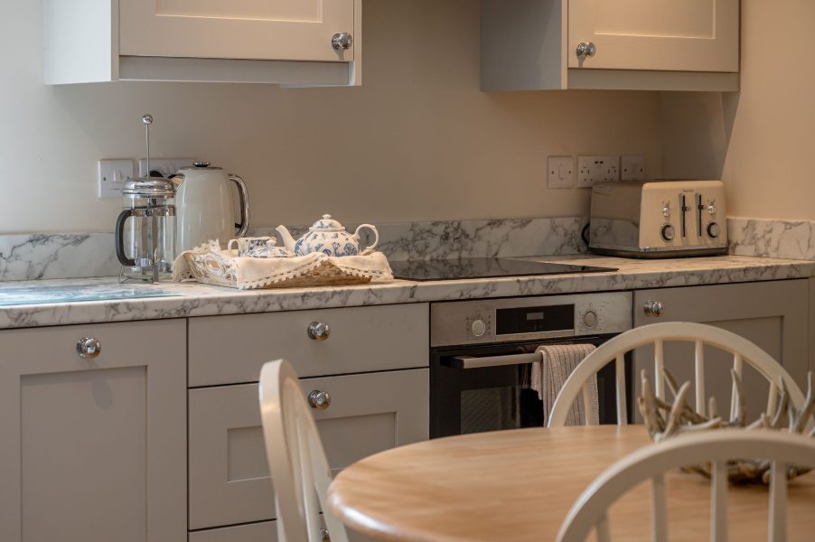 Stylish kitchen detail with marble worktops and appliances at Feathered Nest cottage