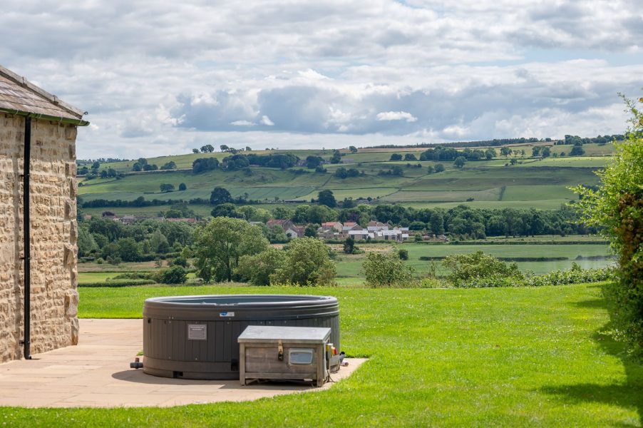Shorthorn hot tub with stunning countryside views across rolling hills and village landscape