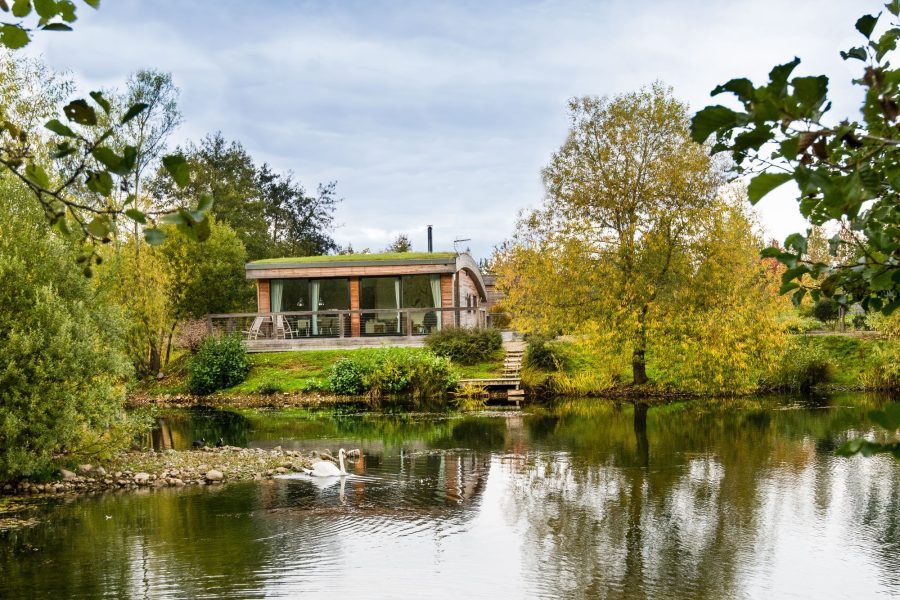 Exterior of Jasper lodge surrounded by nature and water views at Brompton Lakes, Yorkshire.
