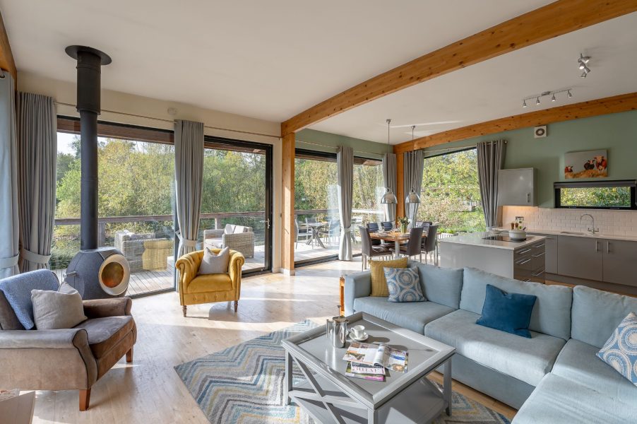 Open-plan lounge and kitchen with modern interiors and natural light in Jasper lodge at Brompton Lakes.