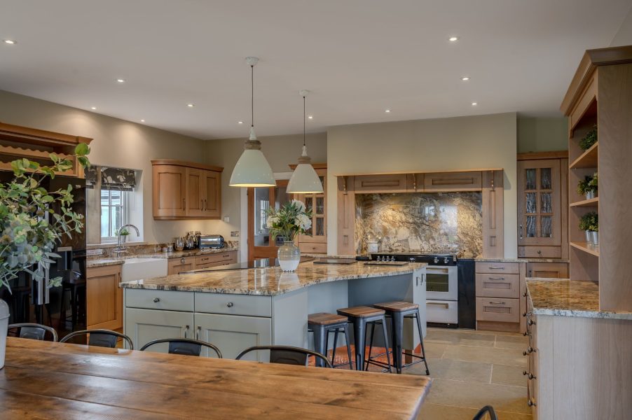 Open-plan kitchen and dining area at Waterloo Lodge with large island, seating and countryside views.