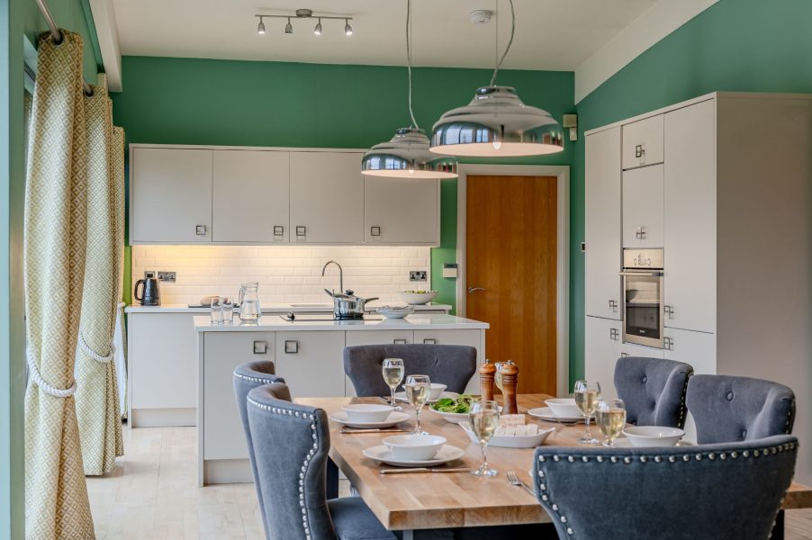 Open-plan kitchen and dining space in Coco lodge at Brompton Lakes with lakeside views.