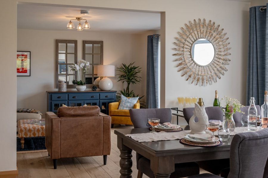 Ellesmere Barn open-plan living and dining area with stylish furnishings, feature mirror and cosy seating space.