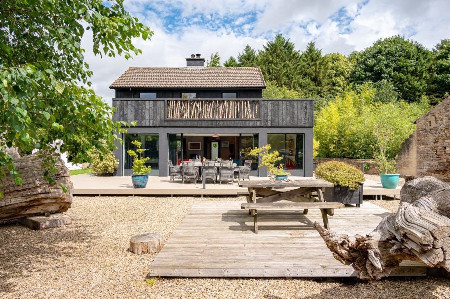 Modern countryside cabin with large terrace, outdoor dining area and garden space.