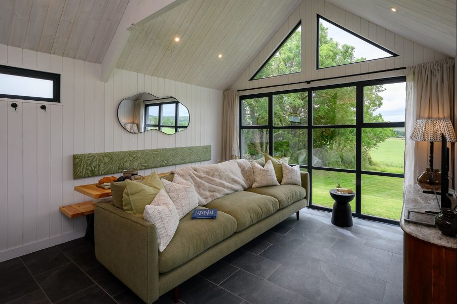 Contemporary living room in Ake lodge with large picture windows, countryside views and stylish modern interiors.