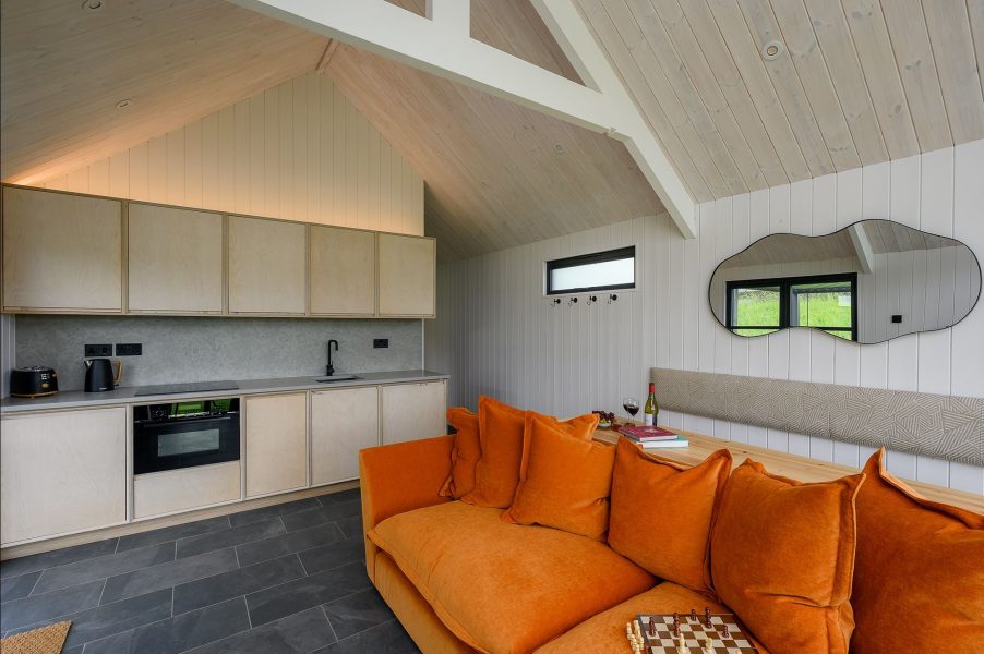 Contemporary kitchen in Olof lodge at Greenbank Lodges with modern appliances and access to the outdoor terrace.