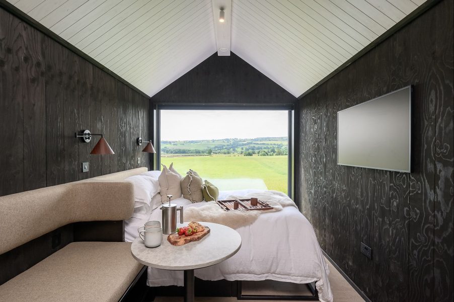 Dark Scandinavian lodge bedroom with panoramic countryside views across North Yorkshire