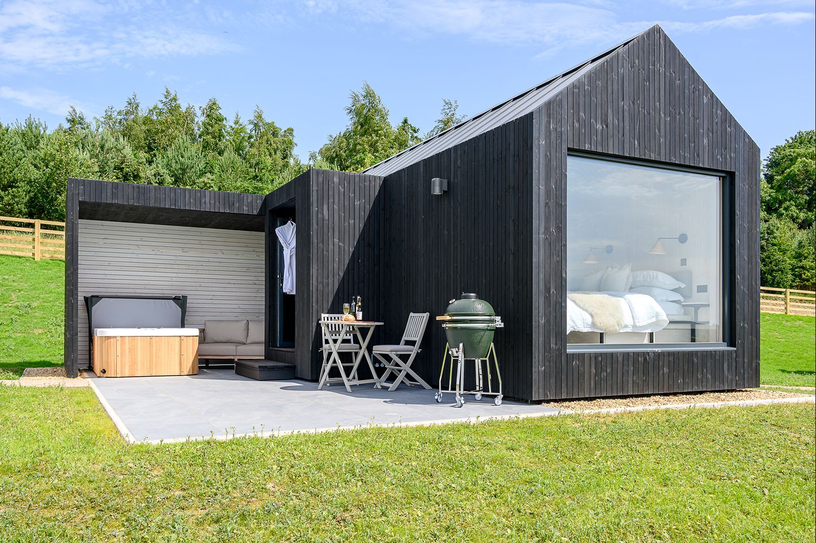 A private hot tub on the covered terrace of a luxury lodge at Greenbank Lodges.