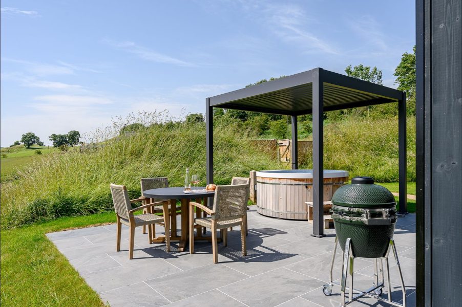 Outdoor dining terrace at Ake Lodge with barbecue, hot tub and luxury lodge accommodation in North Yorkshire.