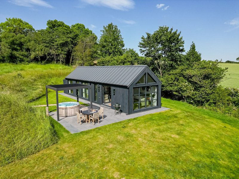 Exterior of Ake Lodge with private patio, hot tub, barbecue and scenic North Yorkshire countryside surroundings.