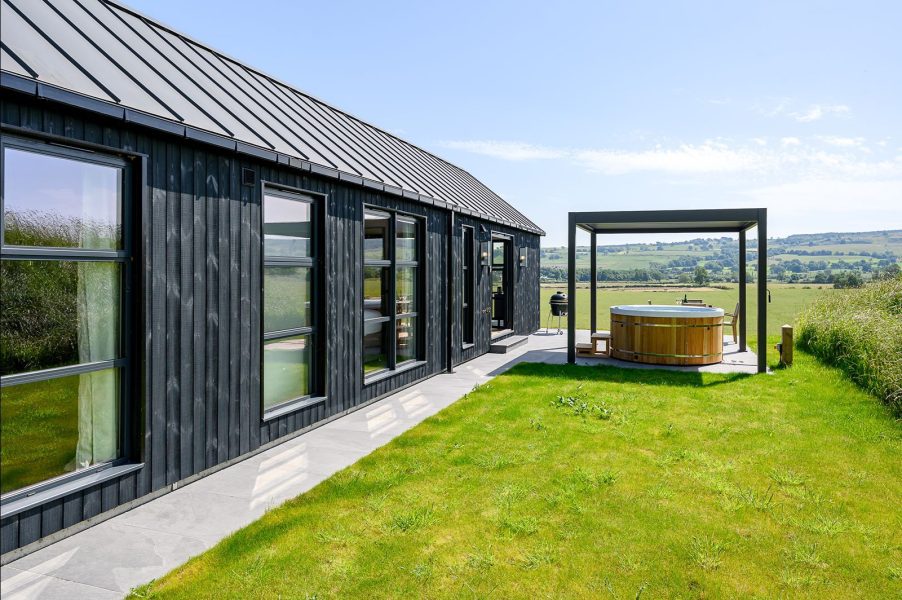 Outdoor dining area at a luxury lodge in North Yorkshire with a pizza oven, grazing board and panoramic countryside views.