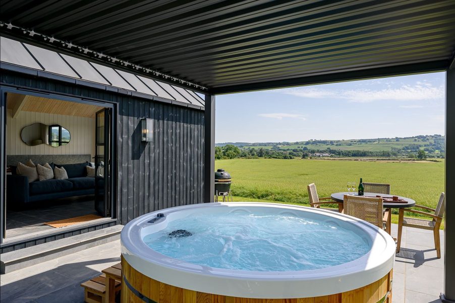 Luxury lodge patio featuring a hot tub and outdoor dining area overlooking the Yorkshire countryside.