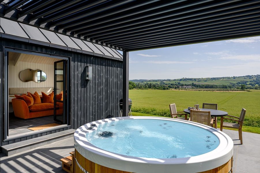 Black wood cabin in North Yorkshire, with countryside views and a hot tub.