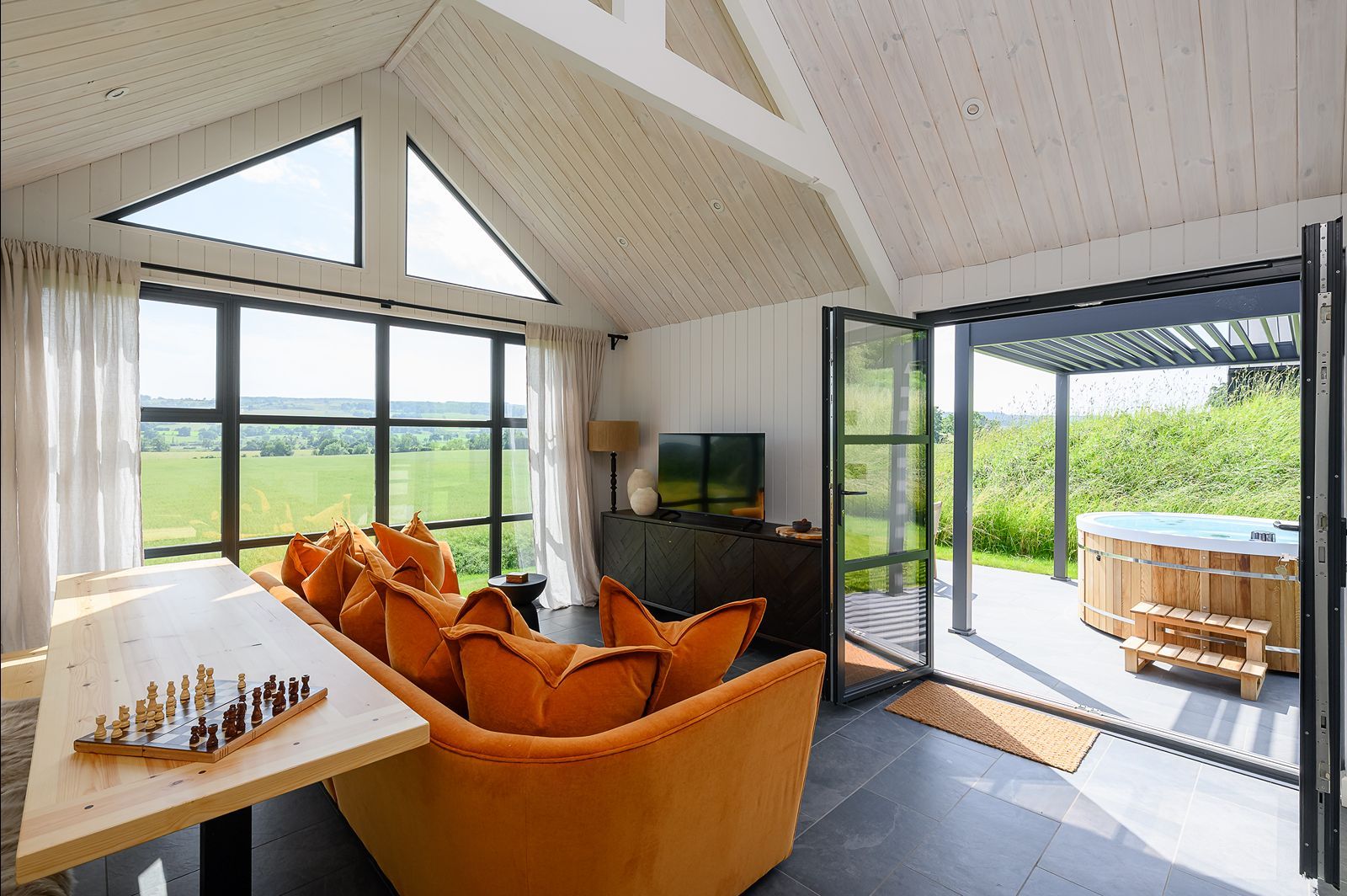 Comfortable lounge seating in Olof lodge with countryside views through large picture windows in North Yorkshire.