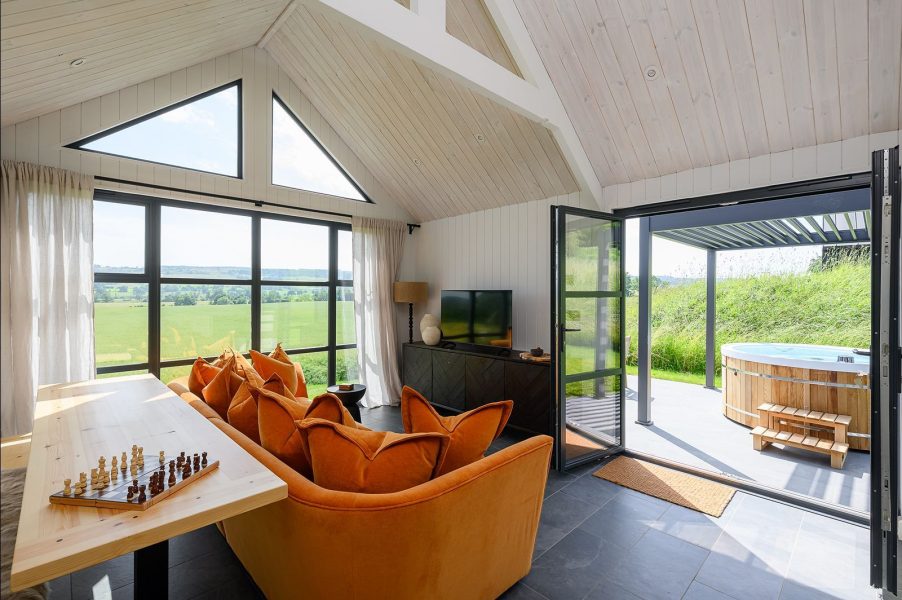 Comfortable lounge seating in Olof lodge with countryside views through large picture windows in North Yorkshire.