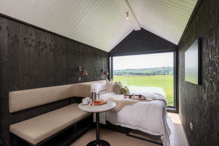 Dark Scandinavian lodge bedroom with panoramic countryside views across North Yorkshire.