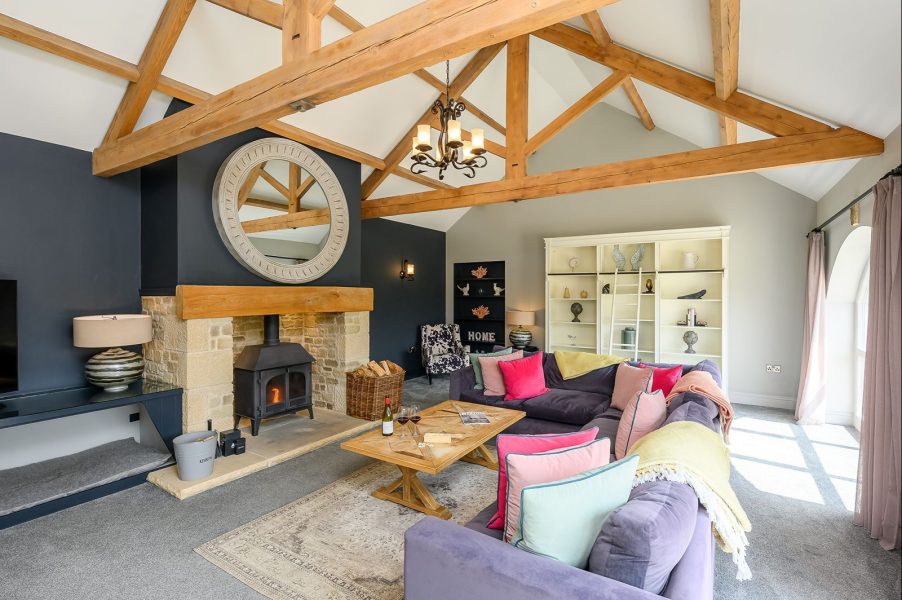 Cosy living room with sofas, soft furnishings and stylish furniture in Kingfisher holiday cottage.
