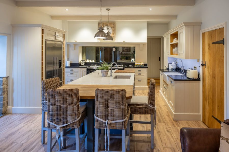 Modern kitchen and large island with seating and appliances in Sun Hill Farmhouse.