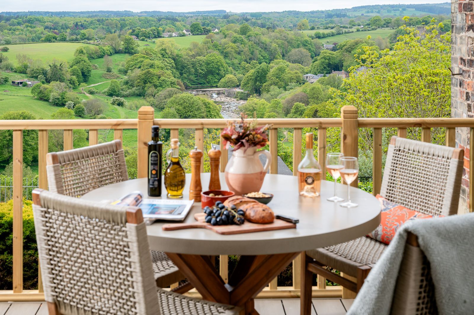 Maison Cottage balcony dining area with countryside views, outdoor table setting and River Swale in the distance