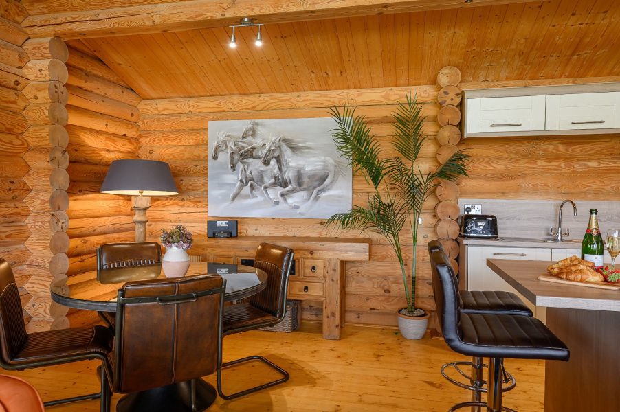 Dining area with leather chairs and wooden walls at Ninetta lodge.