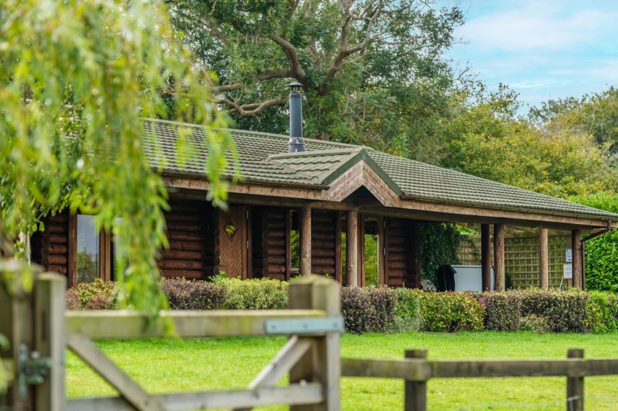 Woodlands log cabin exterior surrounded by countryside with private patio and garden