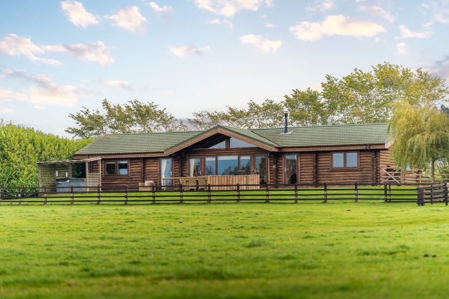 Outside of Ninetta, log cabin with enclosed garden. 