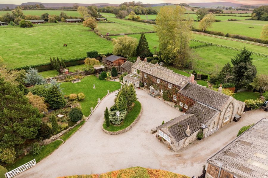 Aerial view of Sun Hill Farm with ivy-covered stone walls, gravel driveway and landscaped garden.